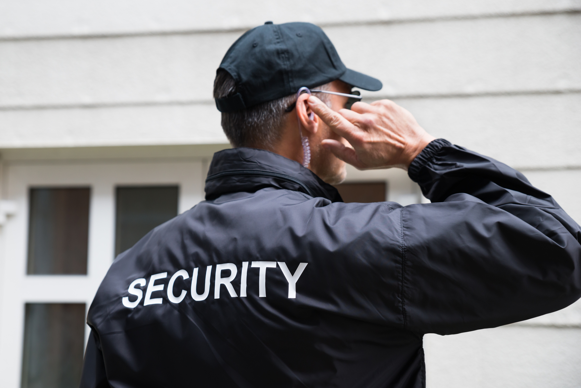 Security staff member wearing a dark uniform and earpiece
