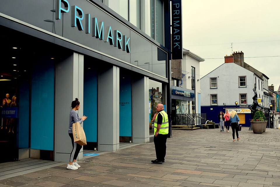 Uniformed security guard on duty outside a retail entrance